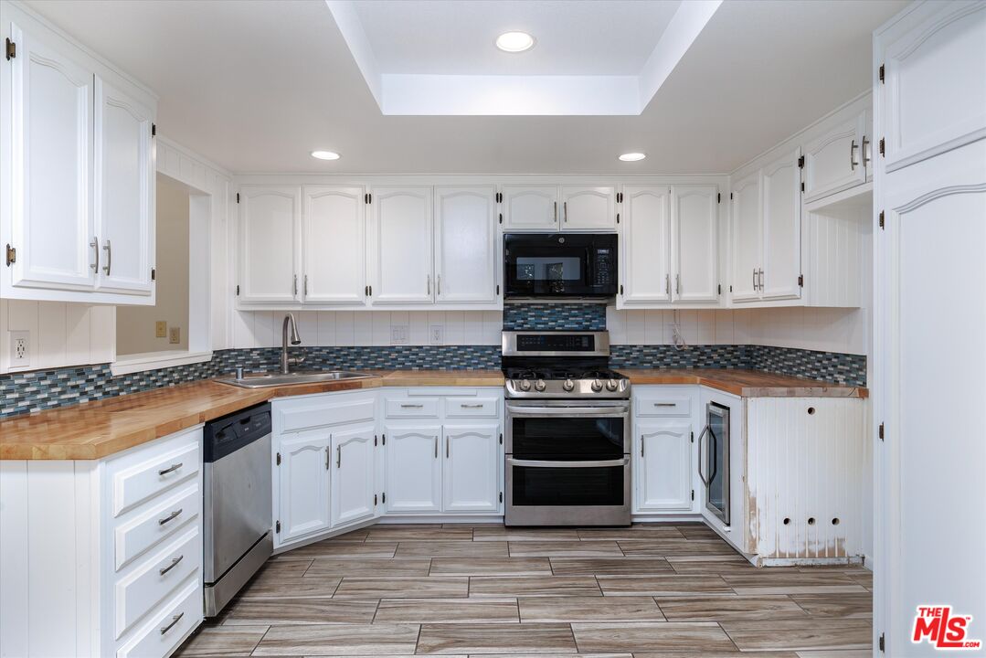 1108 Via Mavis Santa Maria, CA 93455 - Photo 11 of 28 a large kitchen with cabinets stainless steel appliances and a sink