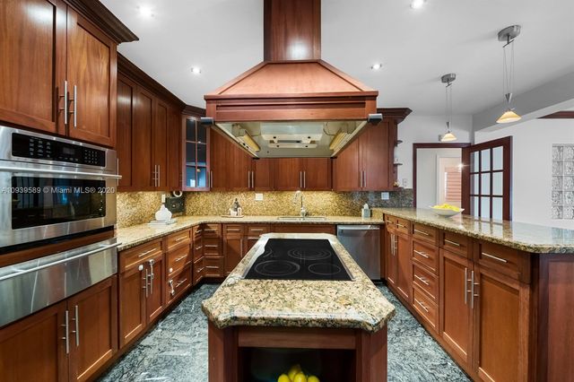 a kitchen with a stove sink and cabinets