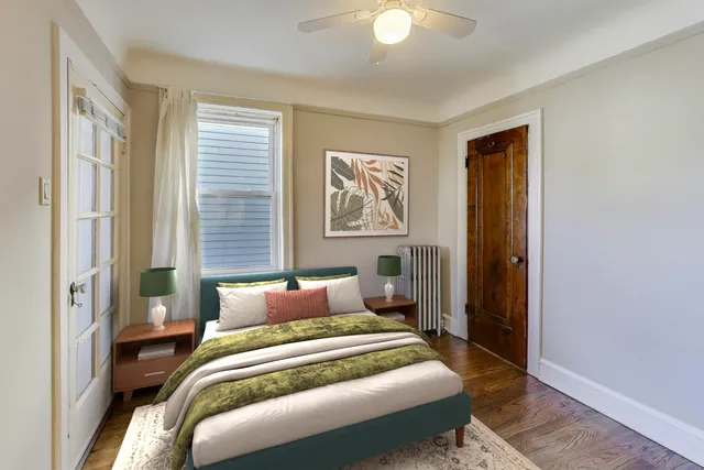 a view of an empty room with window and wooden floor