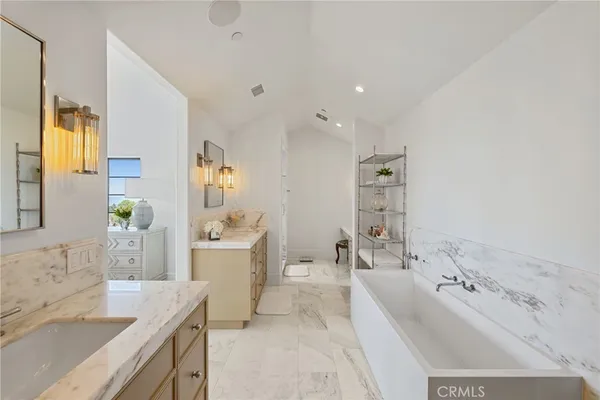 a bathroom with a tub sink and mirror
