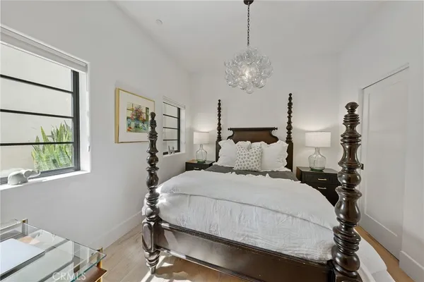 a bedroom with a bed and a chandelier