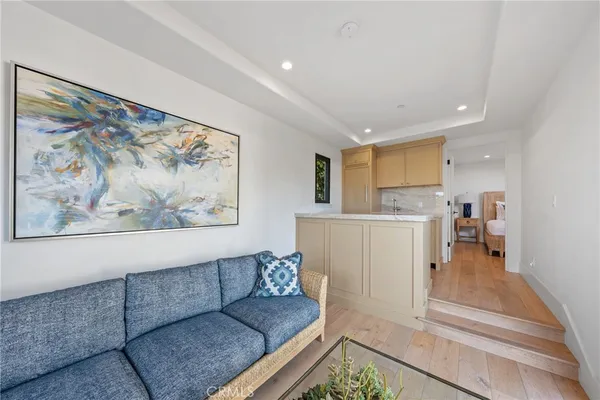 a living room with furniture and a view of kitchen