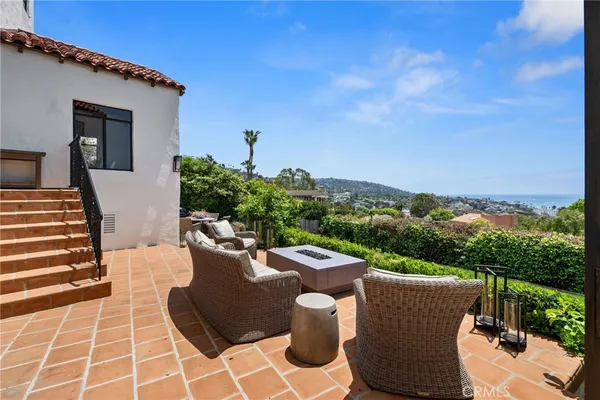a view of a patio with couches and table and chairs with wooden fence