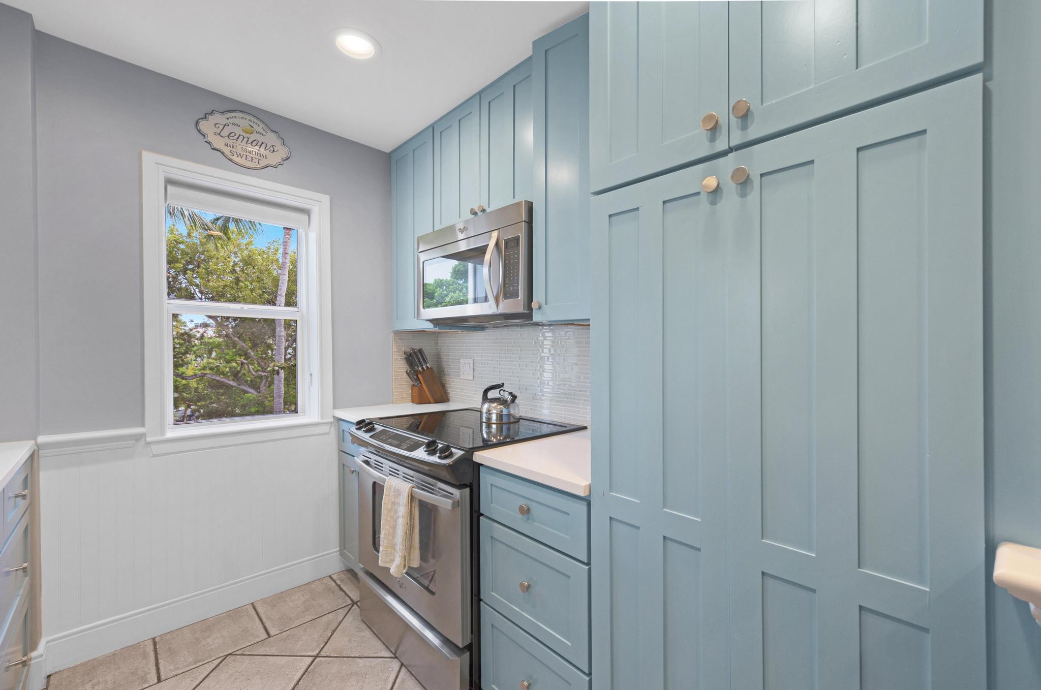115 Front Street, Unit 301 Key West, FL 33040 - Photo 14 of 52 a kitchen with white cabinets and window