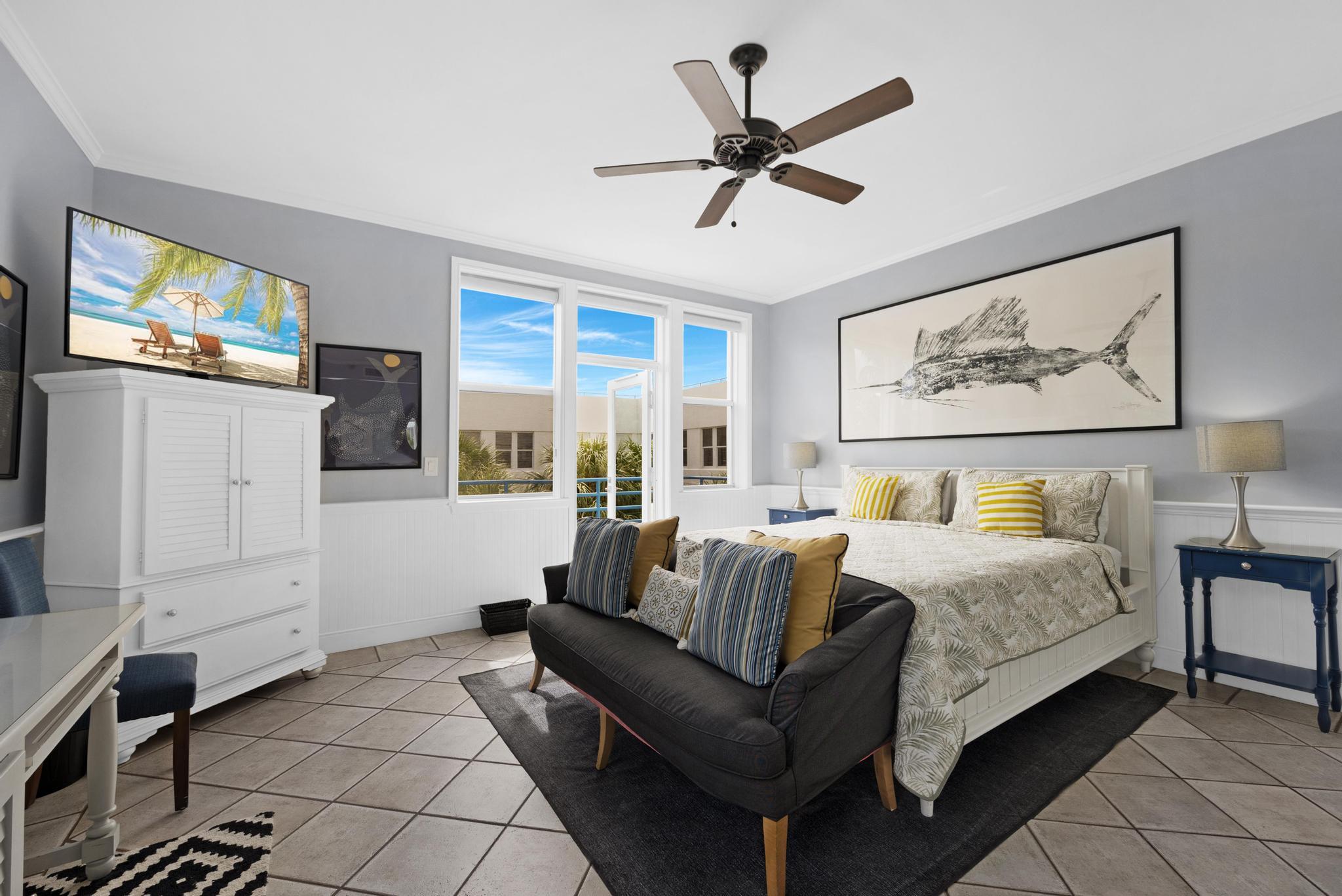 115 Front Street, Unit 301 Key West, FL 33040 - Photo 29 of 52 a spacious bedroom with a bed a couch and a flat screen tv