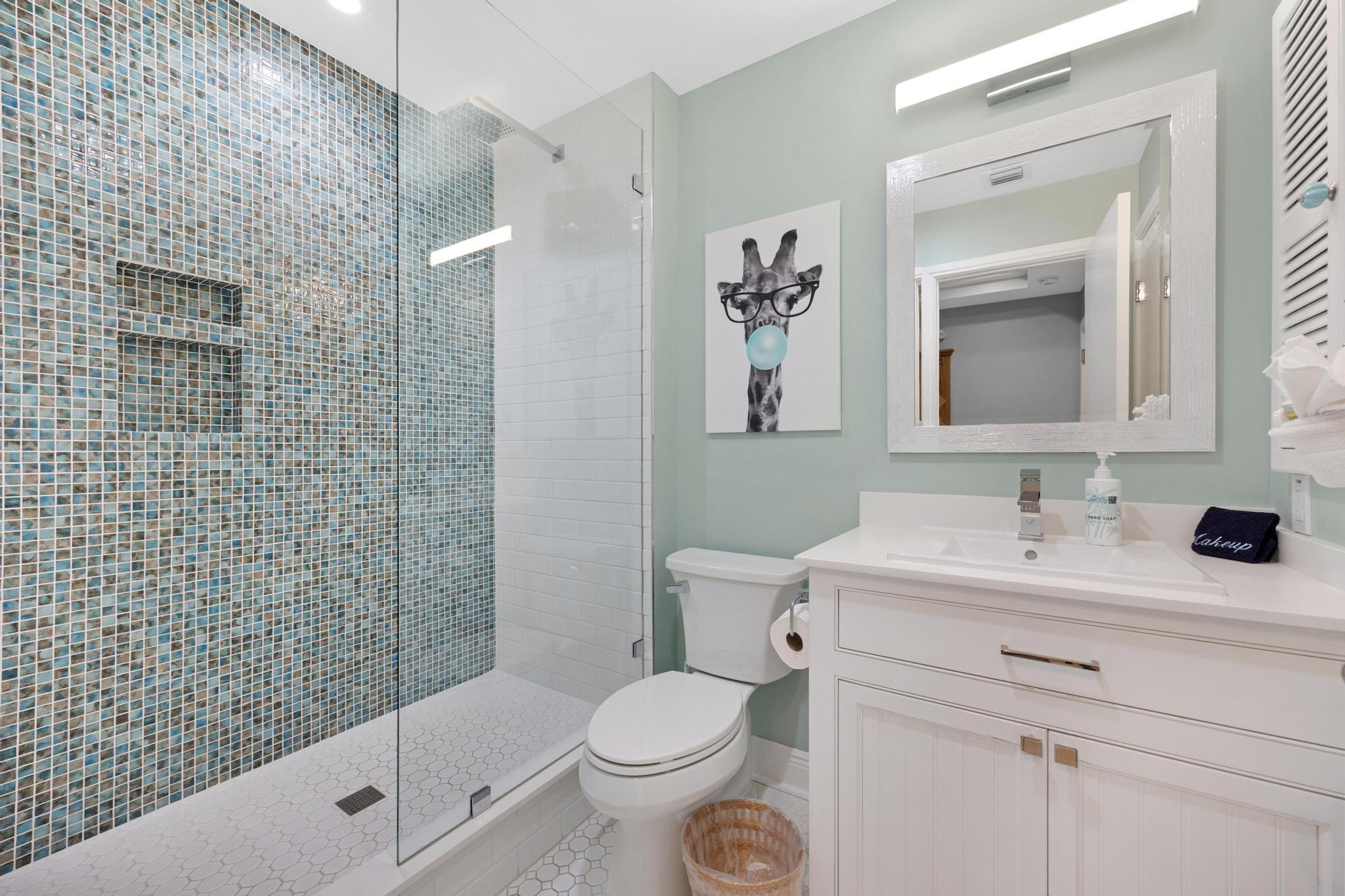 115 Front Street, Unit 301 Key West, FL 33040 - Photo 38 of 52 a bathroom with a toilet sink vanity and mirror