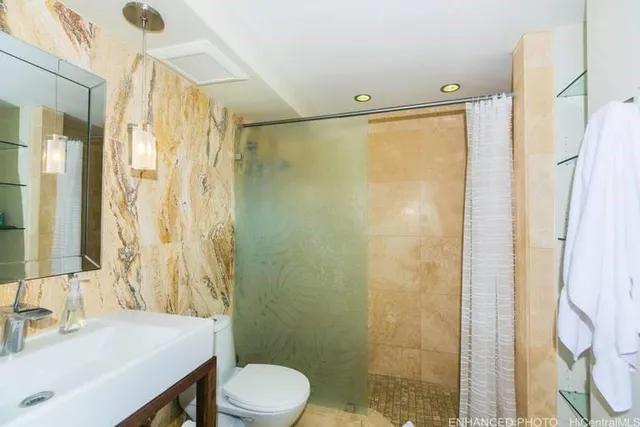 a bathroom with a sink a toilet and shower