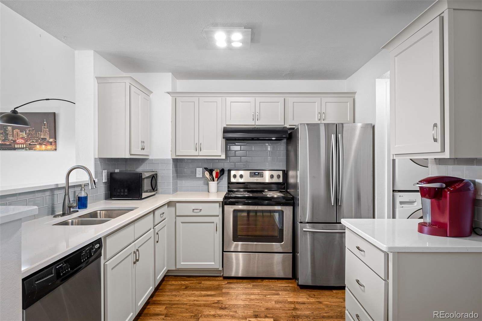 3016 West Prentice Avenue, Unit D Littleton, CO 80123 - Photo 6 of 28 a kitchen with a sink stove and refrigerator