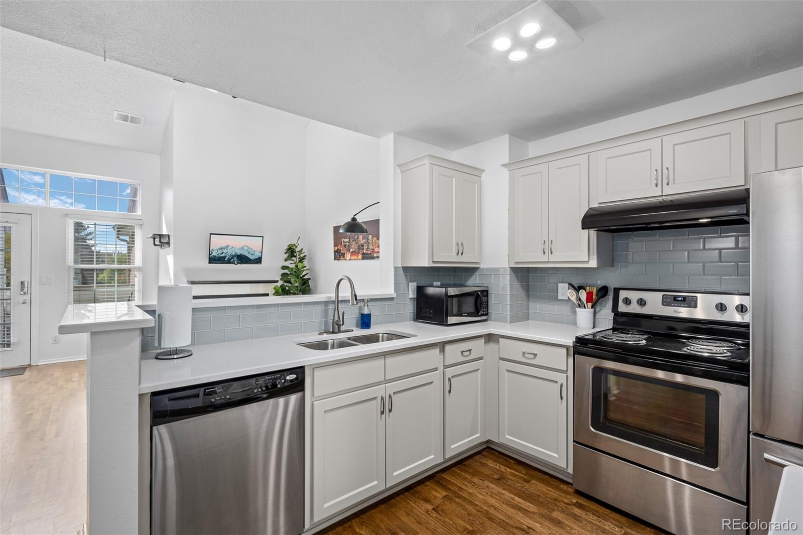 3016 West Prentice Avenue, Unit D Littleton, CO 80123 - Photo 7 of 28 a kitchen with a sink stove and cabinets