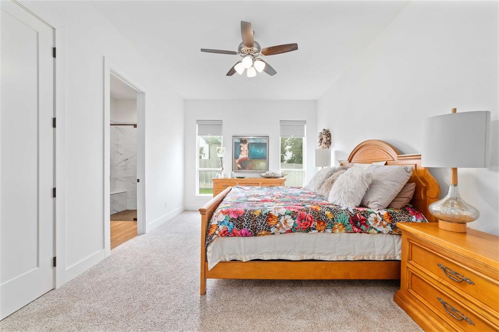 582 Oak Point Drive May, TX 76857 - Photo 19 of 37 a bedroom with a large bed and a chandelier