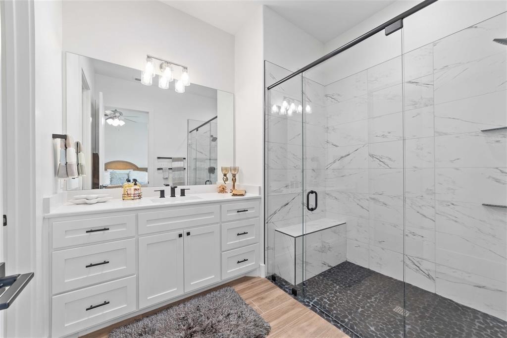 582 Oak Point Drive May, TX 76857 - Photo 20 of 37 a spacious bathroom with a double vanity sink a mirror and a shower