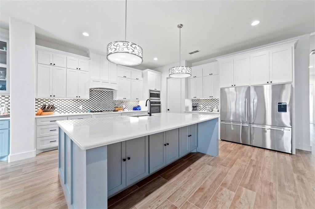 582 Oak Point Drive May, TX 76857 - Photo 9 of 37 a large kitchen with stainless steel appliances a large center island wooden floor and cabinets