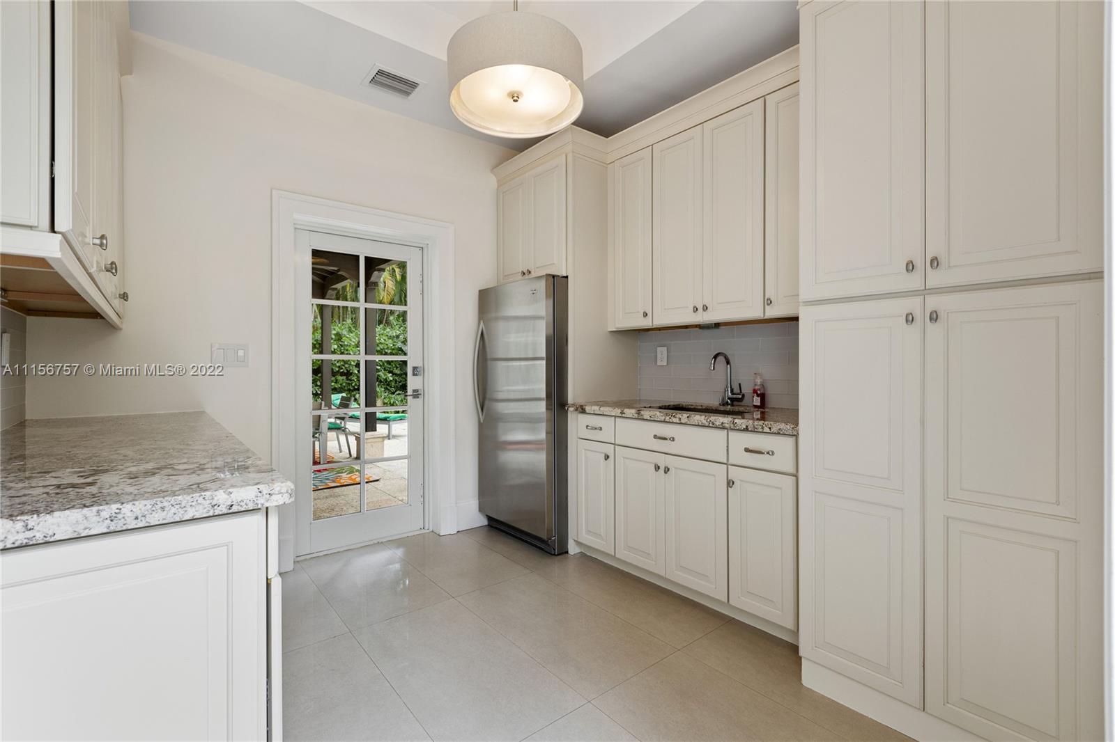 2914 Alton Road Miami Beach, FL 33140 - Photo 36 of 70 a kitchen with granite countertop cabinets and refrigerator