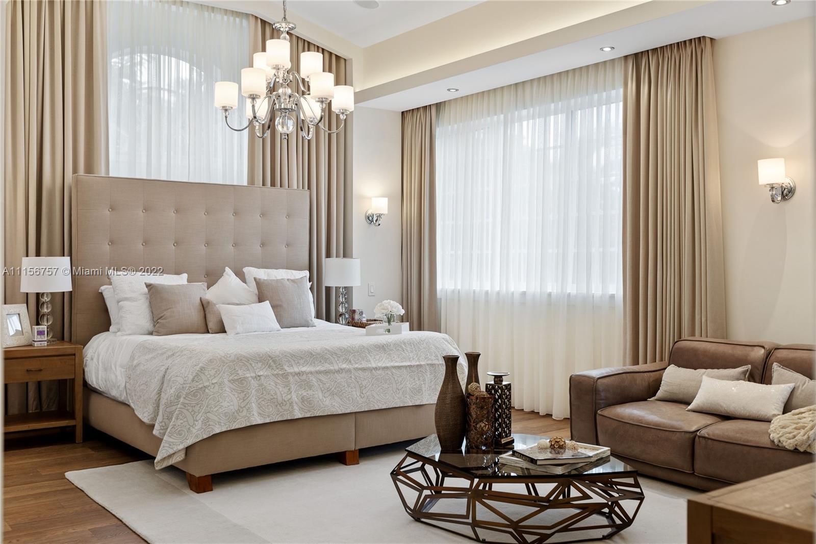 2914 Alton Road Miami Beach, FL 33140 - Photo 38 of 70 a bedroom with a bed couches and a chandelier