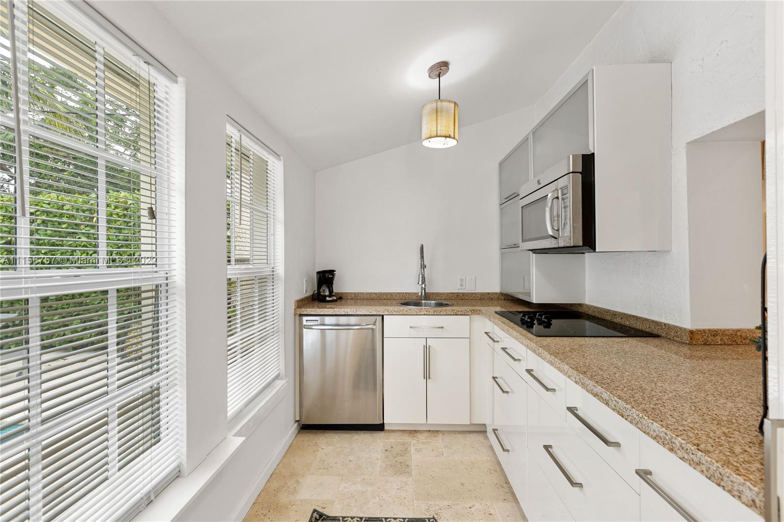 2914 Alton Road Miami Beach, FL 33140 - Photo 55 of 70 a kitchen with stainless steel appliances granite countertop a sink and a granite counter tops with a large window
