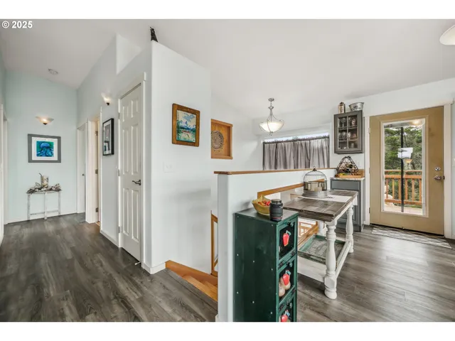 a living room with furniture a flat screen tv and a refrigerator