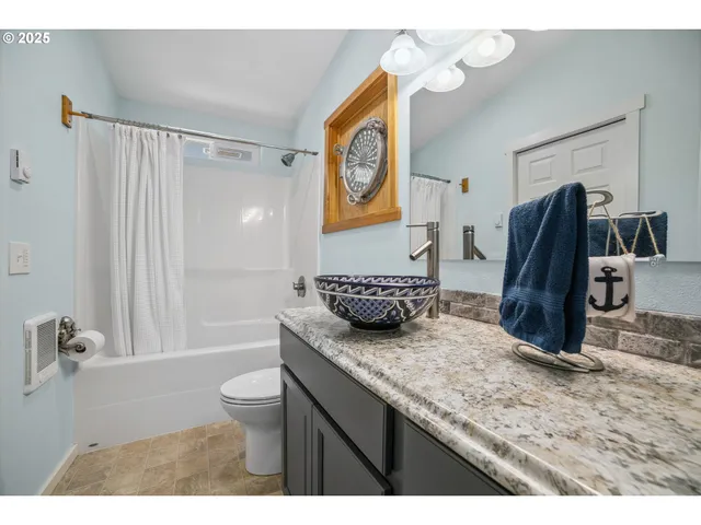 a bathroom with a granite countertop sink a toilet and a shower