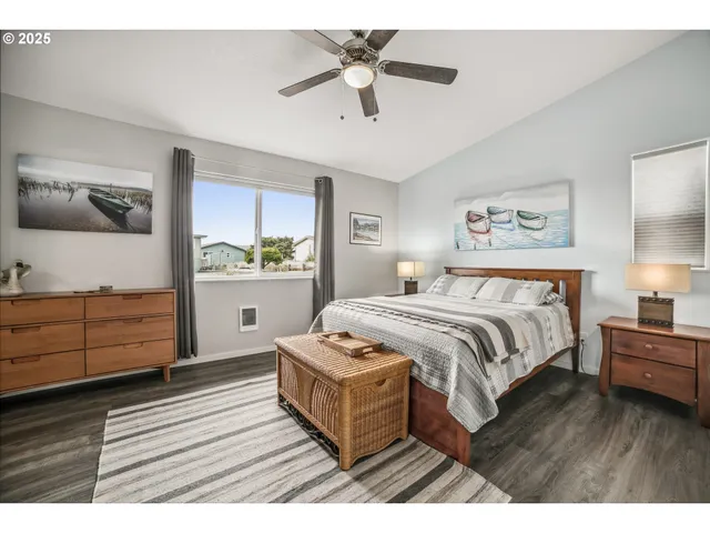 a bedroom with a bed and a dresser with wooden floor
