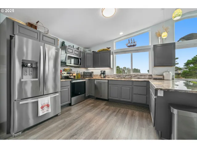 a kitchen with stainless steel appliances refrigerator a sink and a microwave