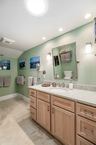 a spacious bathroom with a sink mirror and toilet