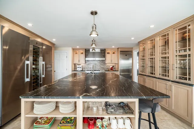 a view of a kitchen with kitchen island a counter top space and stainless steel appliances