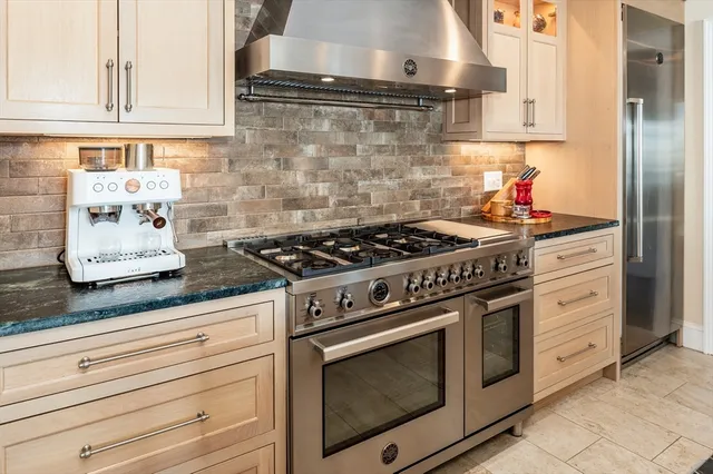 a kitchen with stainless steel appliances granite countertop white cabinets and a stove