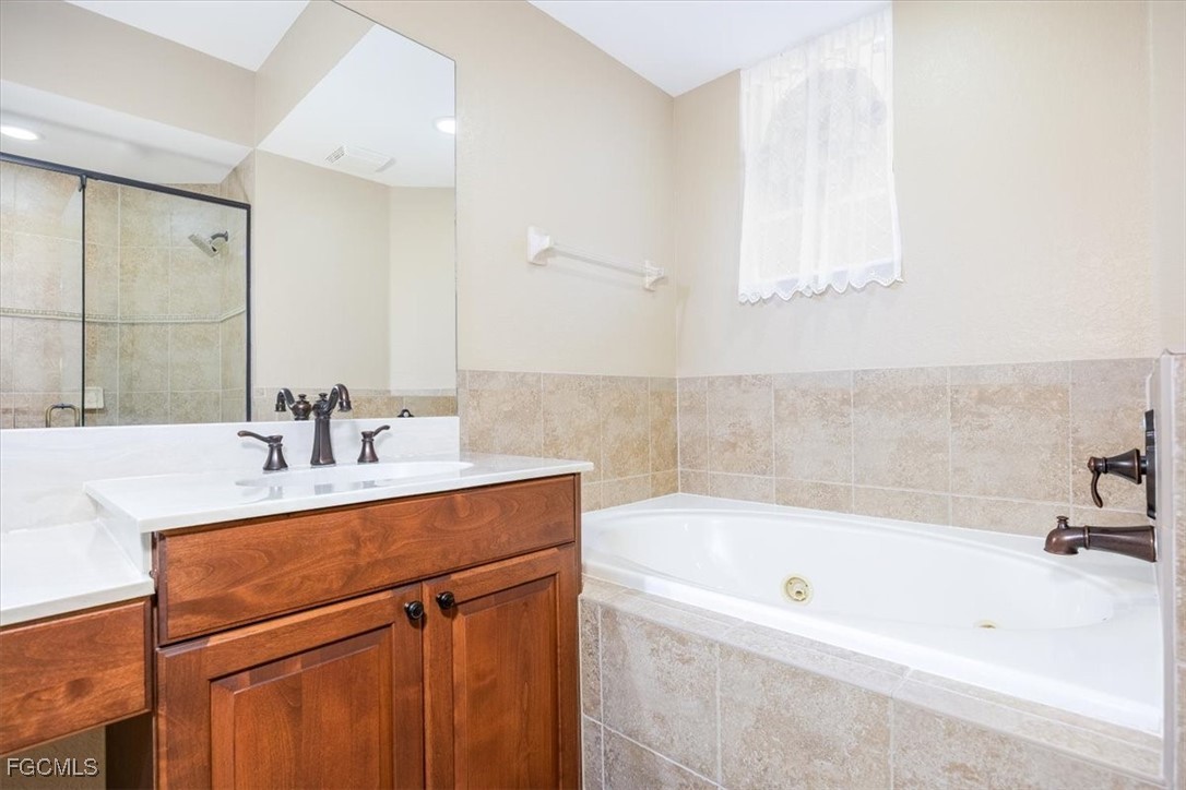 13091 Pebblebrook Ridge Court, Unit 101 Fort Myers, FL 33905 - Photo 19 of 39 a white bath tub sitting next to a bathroom sink