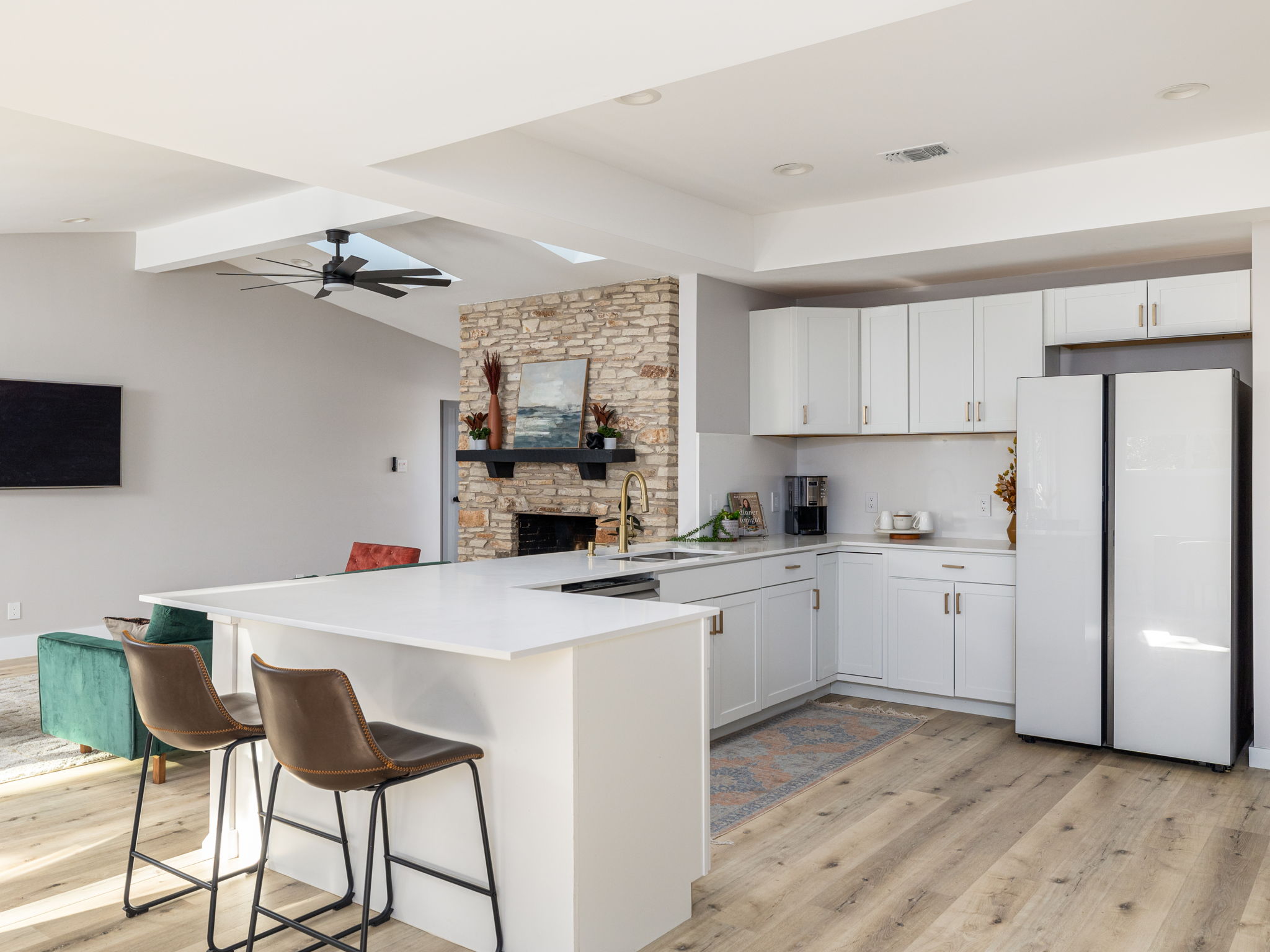 a kitchen with cabinets a sink stainless steel appliances and a refrigerator