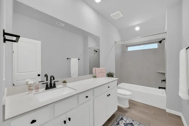 a view of a white house with large windows and a small yard