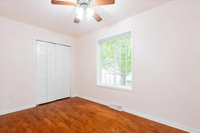 an empty room with a window and wooden floor
