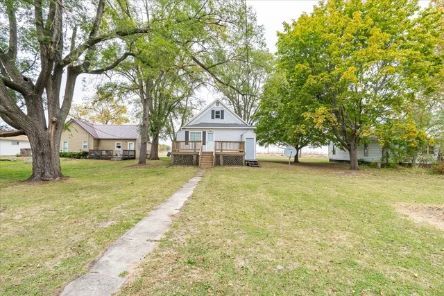 a front view of a house with a garden and trees