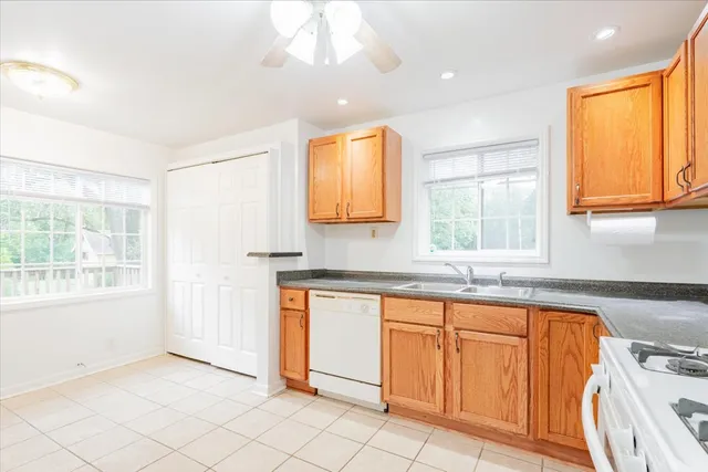 a kitchen with granite countertop a sink window and cabinets