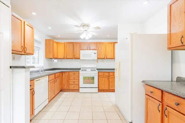 a large kitchen with stainless steel appliances granite countertop a sink and cabinets