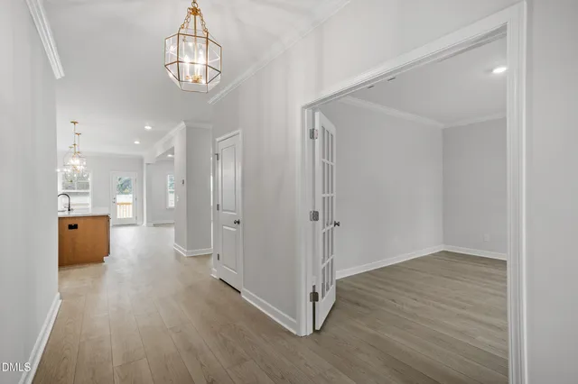 a view of a hallway with wooden floor and a kitchen
