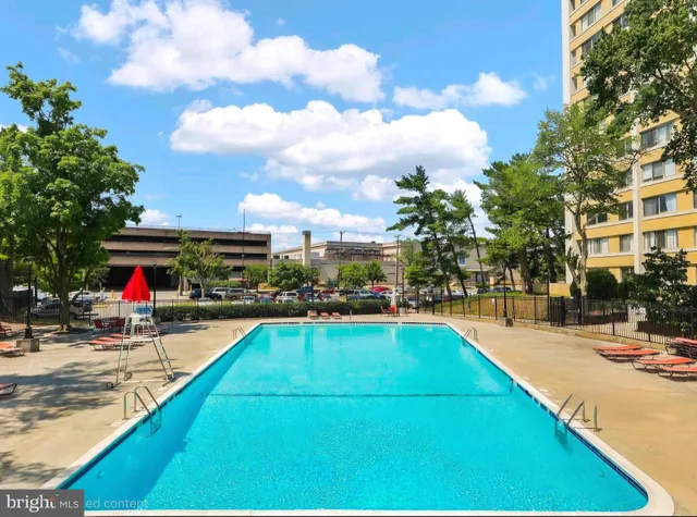 a view of a swimming pool with a patio and a yard