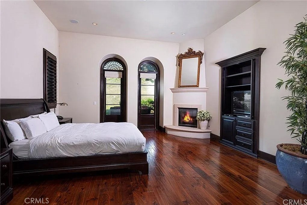 59 Vernal Spring Irvine, CA 92603 - Photo 16 of 33 a bedroom with bed and a fireplace