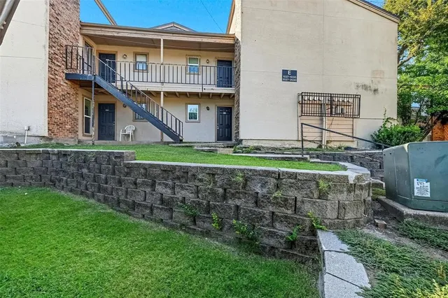 a view of a big house with a big yard plants and large tree