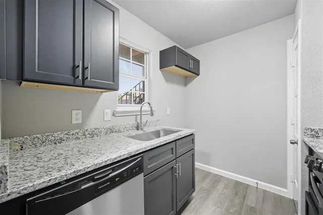 a kitchen with granite countertop a sink and cabinets