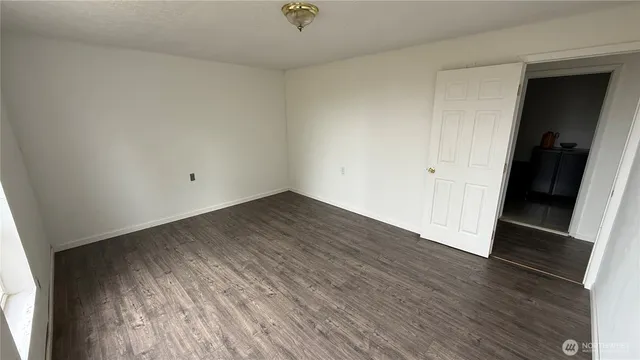 an empty room with wooden floor and closet