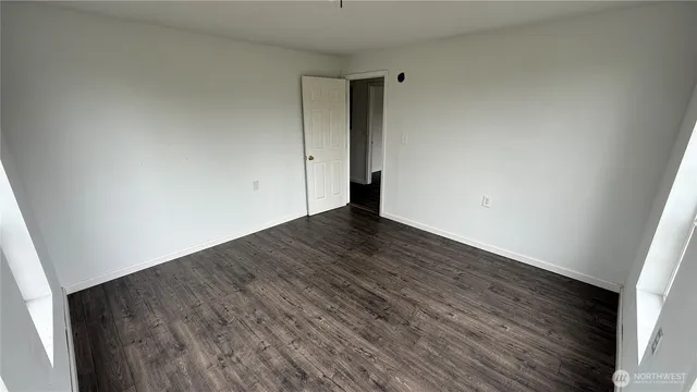 a view of an empty room with wooden floor