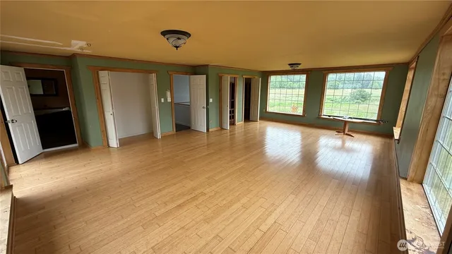 a view of an empty room with glass door and balcony