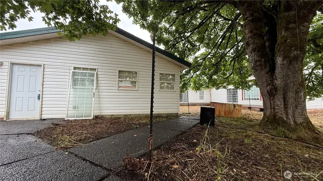 a view of a house with backyard and a tree