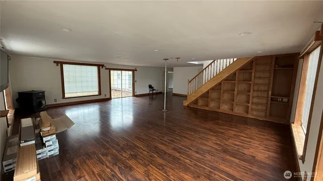 a view of a livingroom with wooden floor and stairs