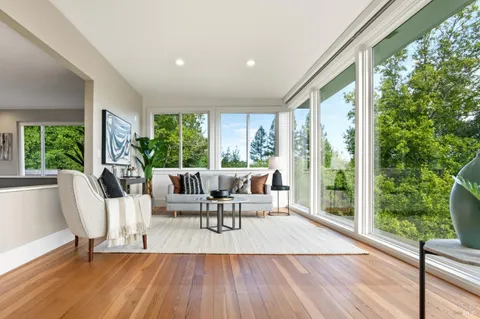 a living room with furniture and a window with garden view