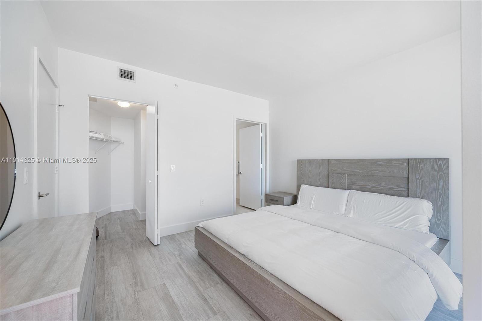 121 Northeast 34th Street, Unit 2109 Miami, FL 33137 - Photo 11 of 19 a bedroom with a bed and a hallway