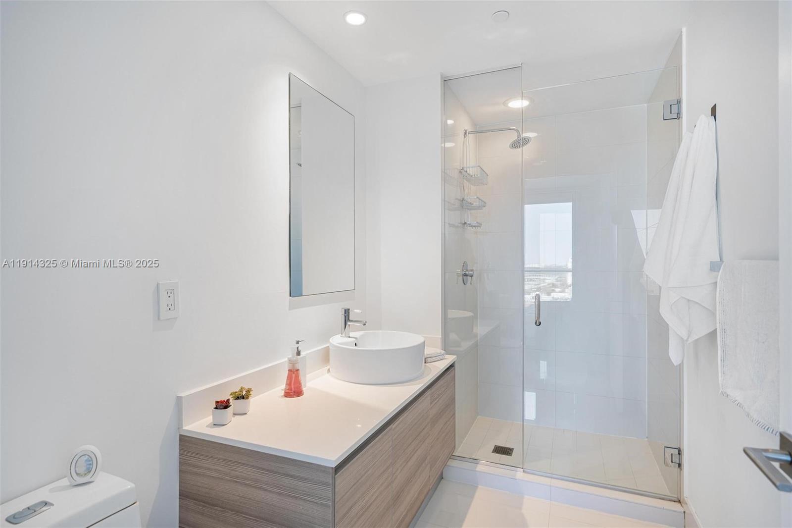 121 Northeast 34th Street, Unit 2109 Miami, FL 33137 - Photo 13 of 19 a bathroom with a tub sink shower and mirror