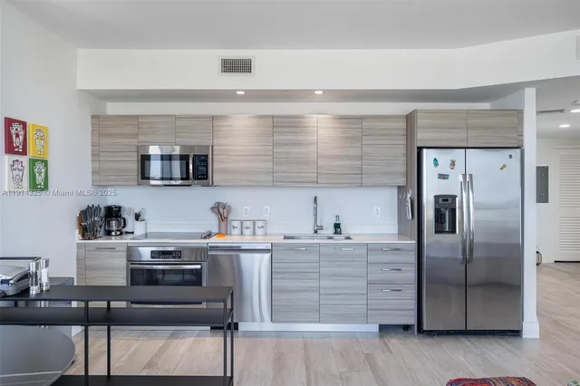 a kitchen with stainless steel appliances a refrigerator and a sink