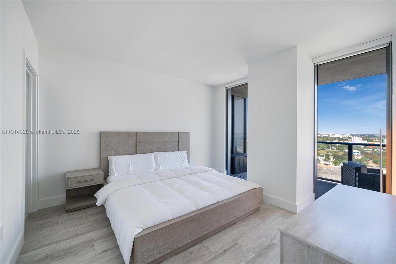 121 Northeast 34th Street, Unit 2109 Miami, FL 33137 - Photo 9 of 19 a bedroom with a bed and a lamp