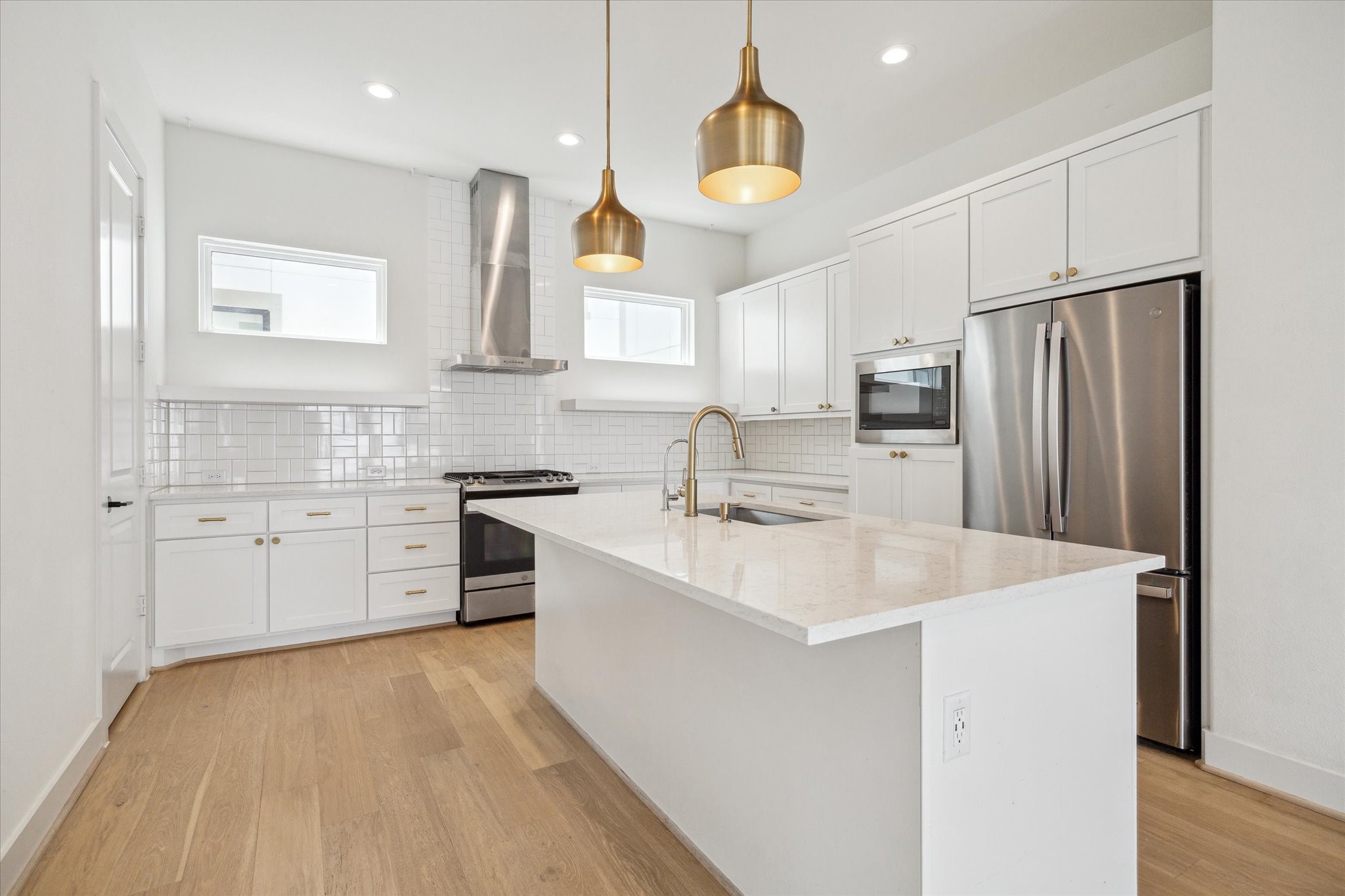 1747 Ojeman Spring Lane Houston, TX 77055 - Photo 6 of 22 a large kitchen with stainless steel appliances a sink a stove a refrigerator and cabinets
