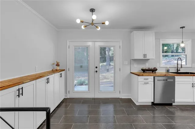 a kitchen with granite countertop white cabinets and stainless steel appliances